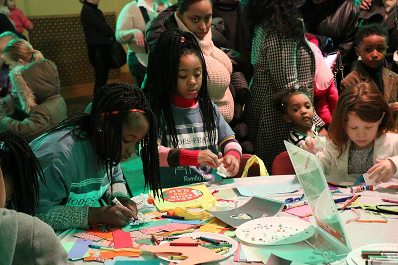 Families enjoying arts and crafts at the Family Fun Zone before a concert